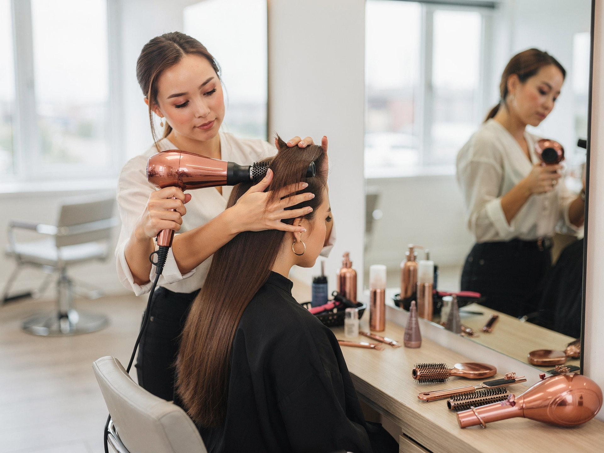Student practicing hair styling at a salon station